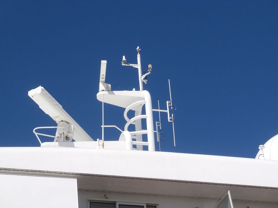 Mastro de navio com antenas de radar contra o céu azul